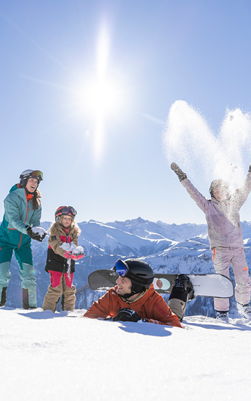 Titelbild - eine Familie ist am Berg und vergnügt sich im Schnee.